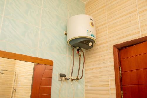 a bathroom with a water heater on a wall at NI-FUR Hotel Cotonou in Cotonou