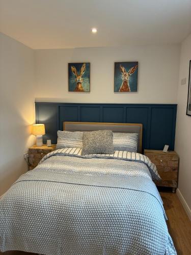 a bed in a bedroom with two pictures on the wall at Clare Escape Ballycastle - Luxury town centre apartment, walk to beach & harbour, near Giants Causeway in Ballycastle