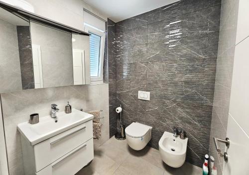 a bathroom with a white sink and a toilet at APP Mary in Novigrad Istria