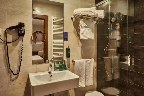 ein Badezimmer mit Waschbecken, Toilette und Dusche in der Unterkunft Hotel Silken Sirimiri in Bilbao
