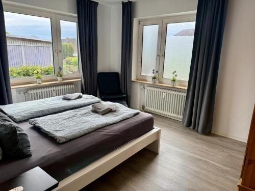 a bedroom with a bed and two windows at Die Schlafstube - Apartments und mehr in Neuharlingersiel
