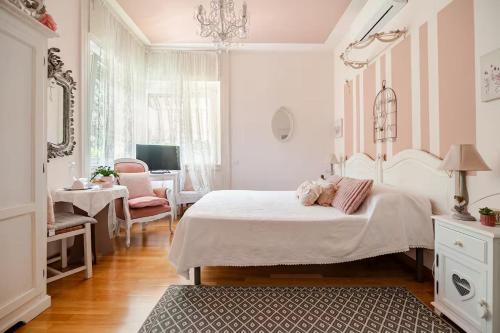 a bedroom with a large white bed and a desk at B&B La Casa di Pamela - 5 min Lago Varese in Varese