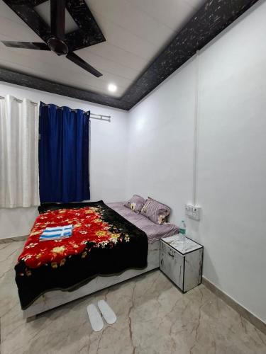a bedroom with a bed and a blue curtain at Shivansh Homestay in Mathura