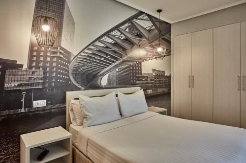 ein Schlafzimmer mit einem Bett und einem Gemälde einer Stadt in der Unterkunft Hotel Silken Sirimiri in Bilbao