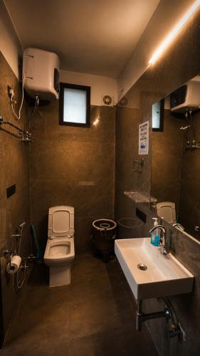 a bathroom with a toilet and a sink at Checkpoint backpacker in New Delhi