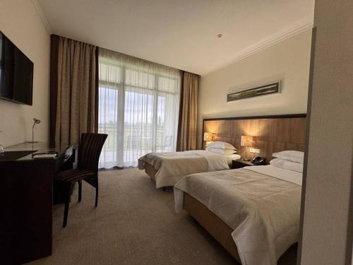 a hotel room with two beds and a desk at Park-Hotel Kidev in Chubynske