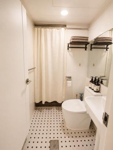 a white bathroom with a toilet and a sink at Coco Villa Sinsa in Seoul