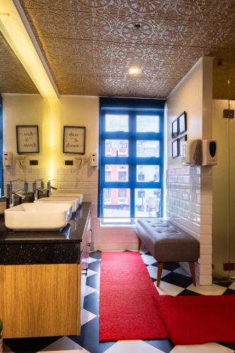 a bathroom with two sinks and a red rug at UNWND Boutique Hotel Makati in Manila