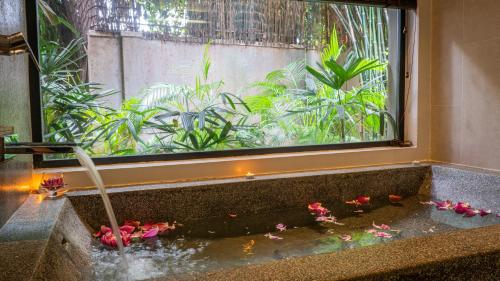 a bath tub with pink flowers in a window at Grange Boutique Siem Reap in Siem Reap