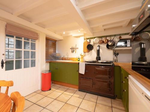 a kitchen with green cabinets and a counter top at The Old Cookery Cottage & Free Parking in Goldsborough