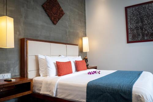 a hotel room with a large bed with red pillows at Grange Boutique Siem Reap in Siem Reap