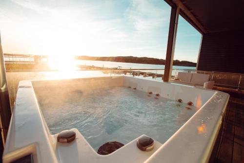 a jacuzzi tub on the deck of a house at Panorama Rorbusuiter in Steinsland