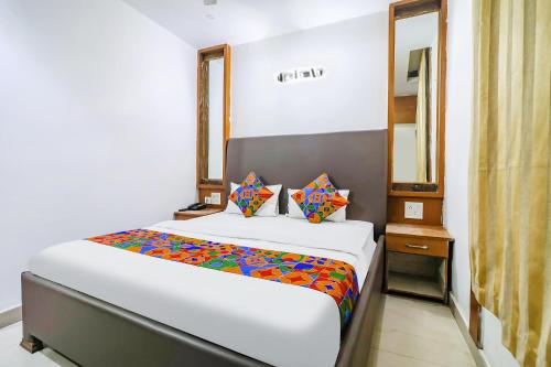 a bedroom with a large white bed and a mirror at FabHotel Nand's Residency in Patna
