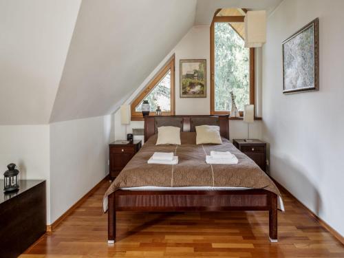 um quarto com uma cama e duas janelas em TatryTop Apartamenty Comfort em Zakopane