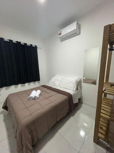 a bedroom with a bed and a air conditioner at Beautiful Cozy Beach House Accommodation in Guaratuba