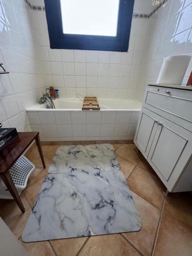 a bathroom with a bath tub and a rug on the floor at Lilas house in Les Lilas