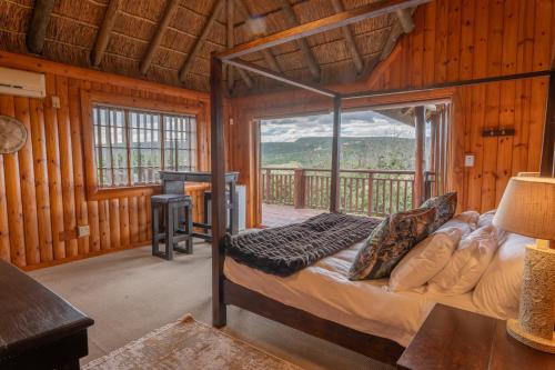 a bedroom with a bed and a large window at Addo Nyala Guest Lodge in Paterson