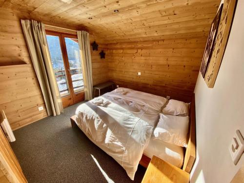 a bedroom with a bed in a wooden cabin at Chalet Le Jeuna in Morgins