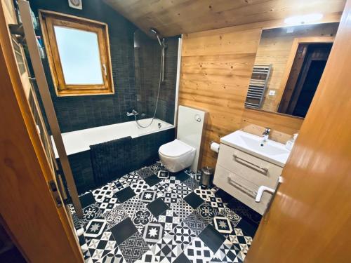 a bathroom with a black and white tile floor at Chalet Le Jeuna in Morgins