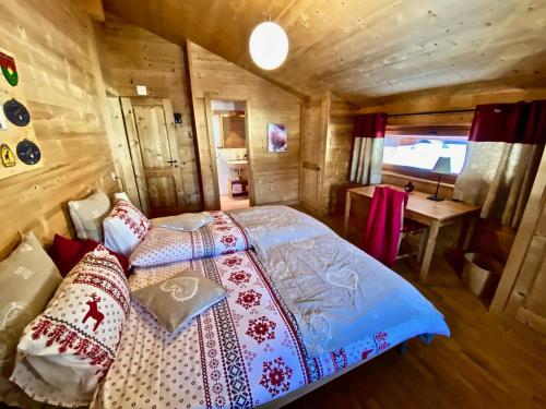 a bedroom with a bed in a wooden cabin at Le Mélézin Bleu in Morgins