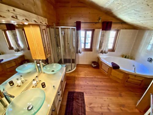 a large bathroom with two sinks and a tub at Le Mélézin Bleu in Morgins
