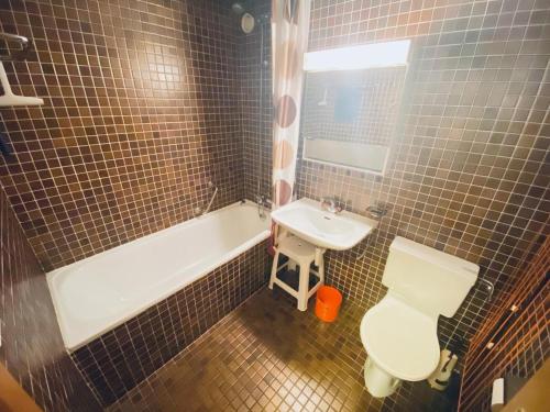 a bathroom with a tub and a sink and a toilet at 4 person apartment in central location in Morgins