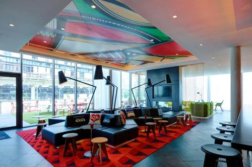 a lobby with couches and tables in a building at citizenM Paris La Défense in Nanterre