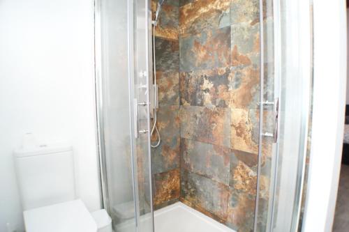 a bathroom with a shower with a stone wall at Atico Sagrada Familia in Barcelona