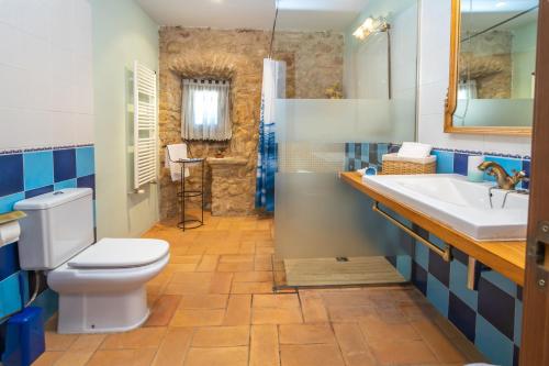 a bathroom with a toilet and a sink and a shower at Can Mas in Fontcuberta