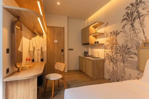 a bedroom with a bed and a desk and a kitchen at Solaris Hotel Malang in Malang