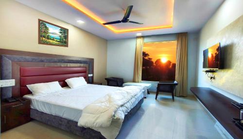 a bedroom with a bed and a ceiling fan at Ramaya Hotel & Banquet in Sidhaulī
