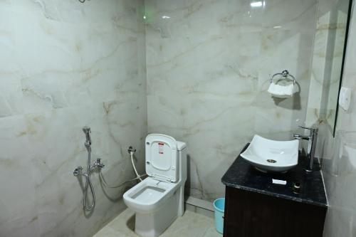 a bathroom with a white toilet and a sink at Ramaya Hotel & Banquet in Sidhaulī
