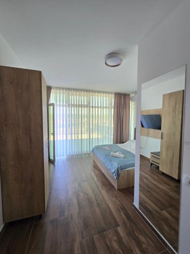 a bedroom with a bed and a large window at Hotel Arbëri Events in Rahovec