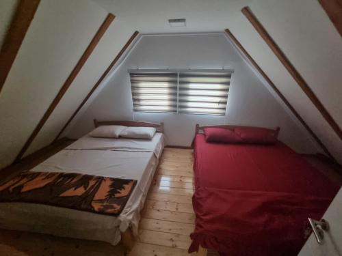 an attic room with two beds and a window at Kutak u Vranicu in Vranic