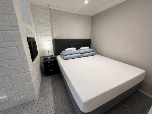 a bedroom with a white bed with two pillows on it at Pool & Sauna Retreat - Private Studio Apartment Porsgrunn in Porsgrunn