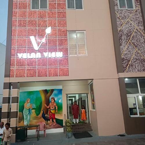 a building with a sign on the side of it at Velan view in Palni