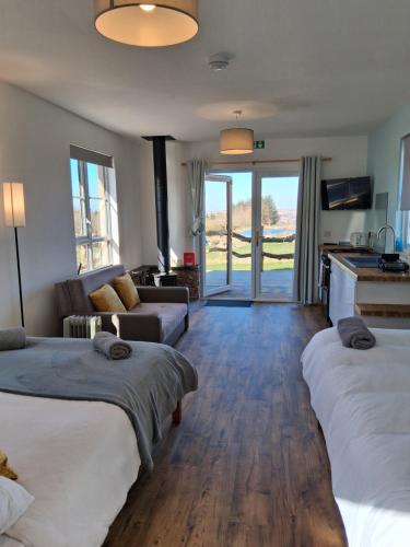 a bedroom with two beds and a living room with a couch at Cabin View in Cuminestown