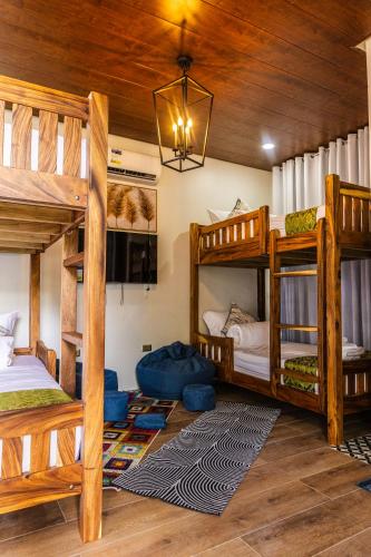 a room with three bunk beds and a chandelier at Uno Maya by Araw Residences in Nasugbu