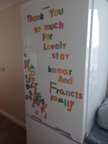 a refrigerator with magnets on the side of it at Large countryside home in Tow Law