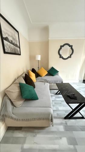 two beds in a room with green and yellow pillows at Stirling Steet in Wallasey