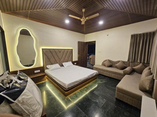 a bedroom with a bed and a couch at Mahak'sVilla in Indore