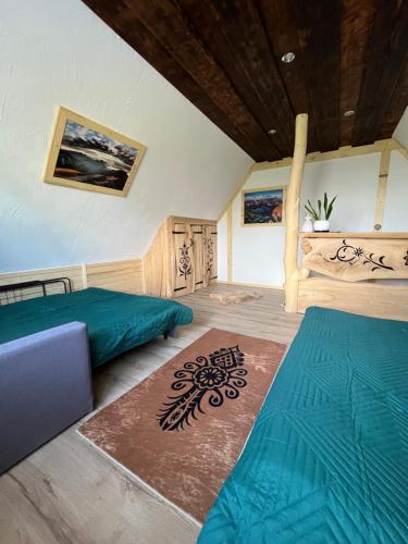 a bedroom with two beds and a rug at Domek Gabi in Ząb