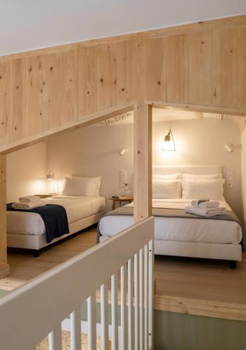 two beds in a room with wooden walls at Orchard in Athens