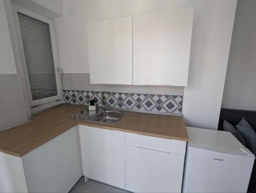a small kitchen with white cabinets and a sink at MiPA in Milazzo