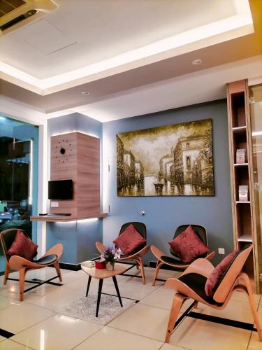 a living room with chairs and a painting on the wall at Rivero Boutique Hotel Melaka in Malacca