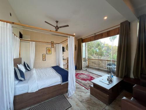 a bedroom with a large bed and a balcony at Magnetic Ridge Kasar in Hawālbāgh