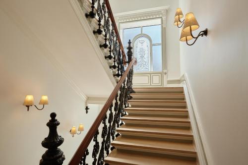 a staircase in a home with white walls and wooden stairs at Henriks Hotel in Copenhagen