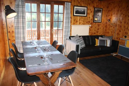 a living room with a table and a couch at La Moussiere in Morgins