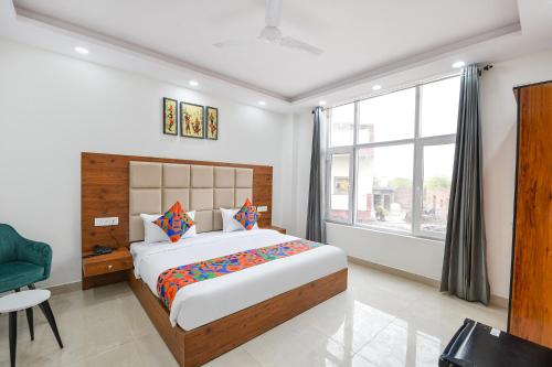 a bedroom with a large bed and a window at FabHotel Evegreen, Faridabaad in Faridabad