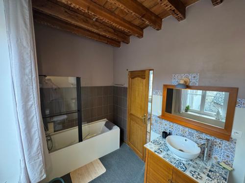a bathroom with a sink and a bath tub at MAISON DE VACANCES aU 91 in Ardres